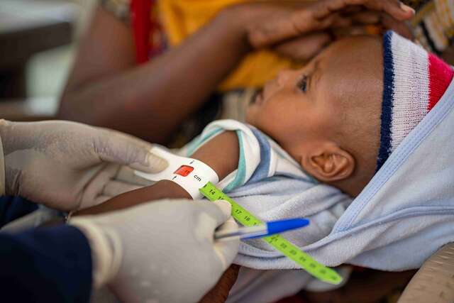 In Gedaref, Sudan, Hermon, an 18-month-old child, receives a screening from an IRC nutrition specialist. The red coloring on the tape indicates a severe risk of malnutrition.